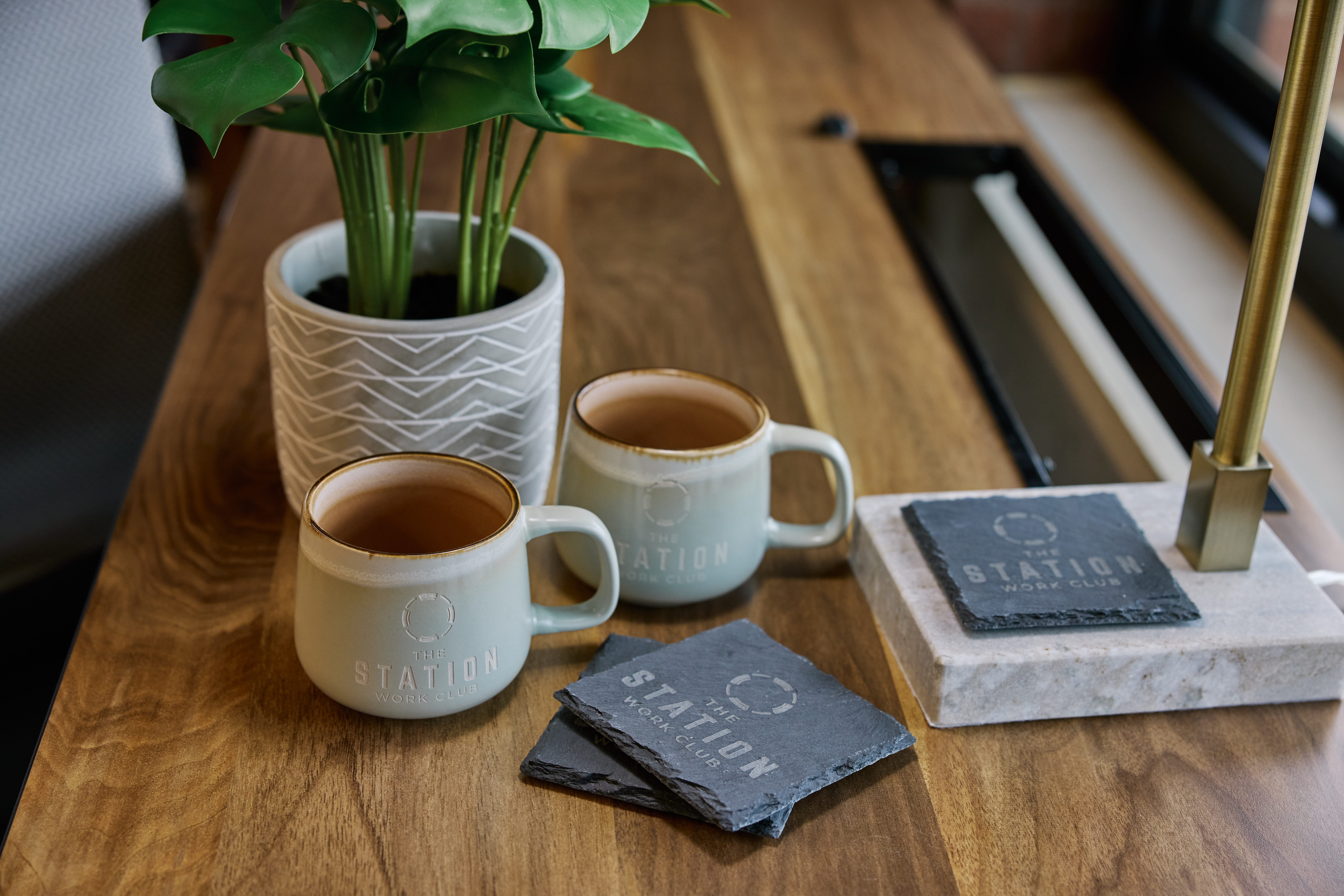 The Station Work Club branded coffee mugs and slate coasters