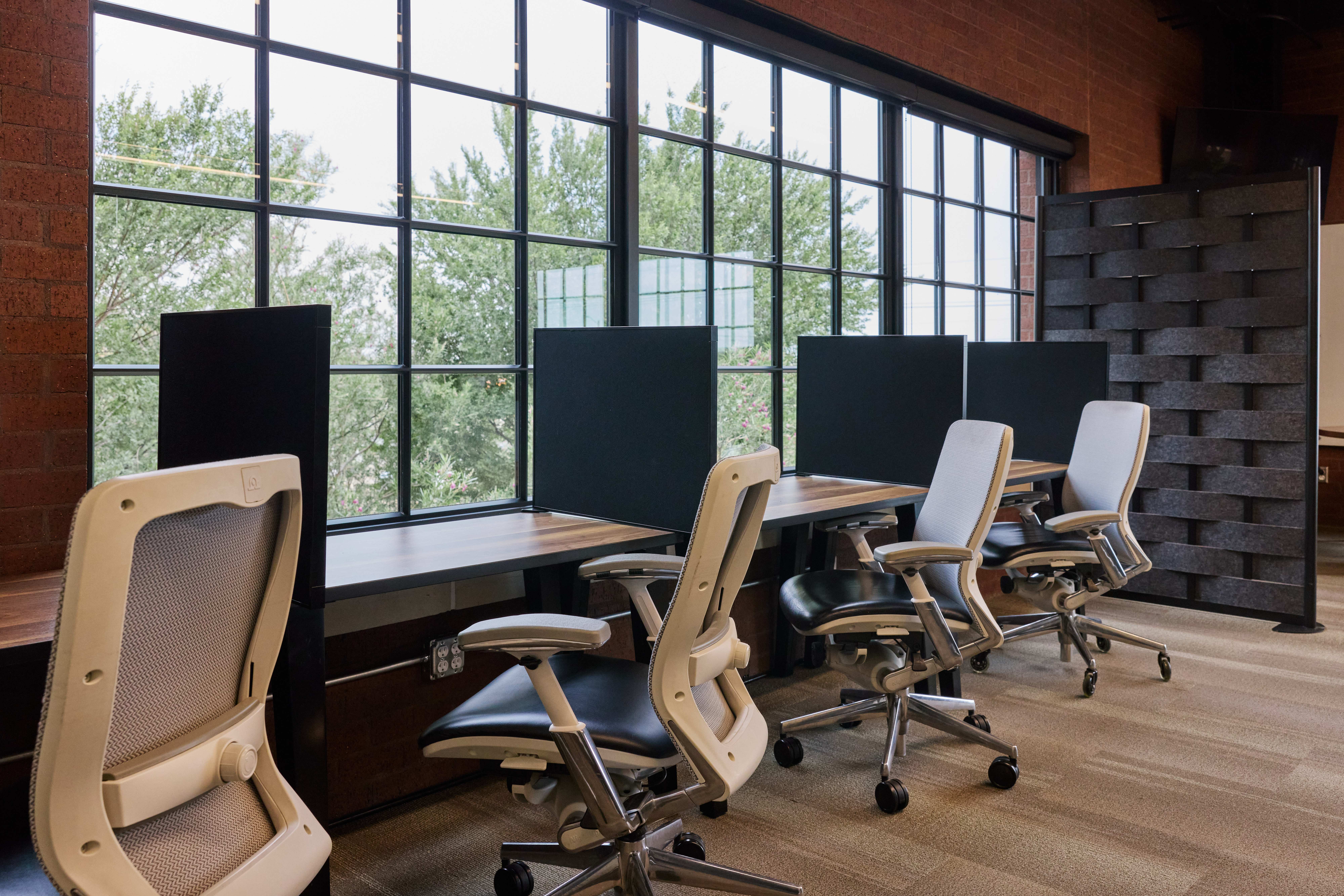 Dedicated focus desks with privacy dividers by the windows