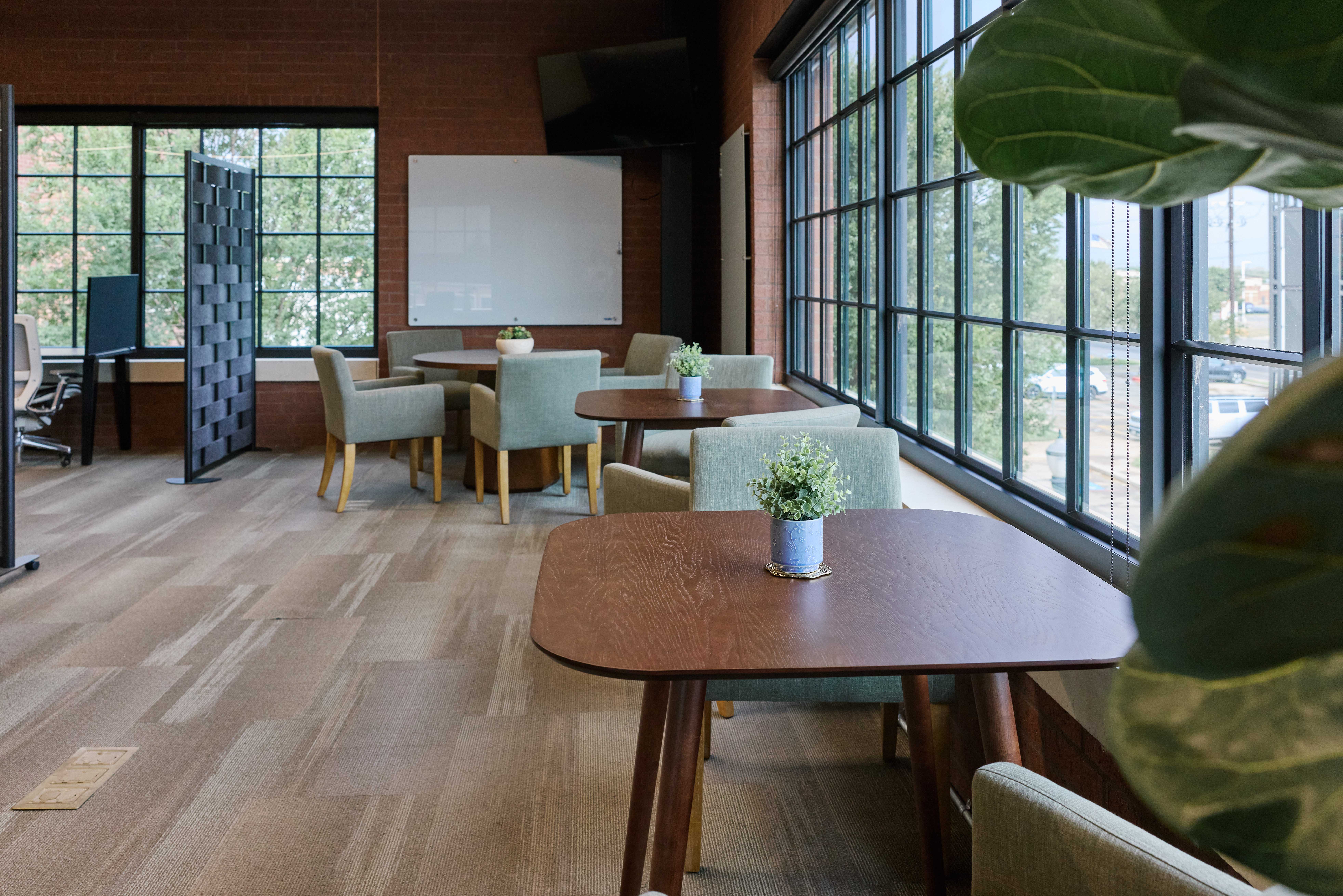Meeting area with seating, glass whiteboard, and a display